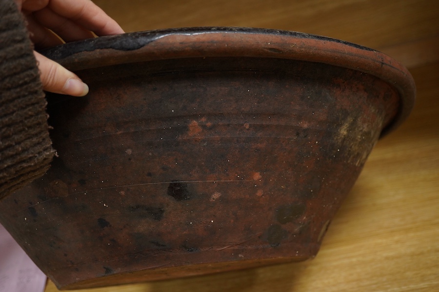 A large 19th century black glazed stoneware dairy bowl, 49cm diameter